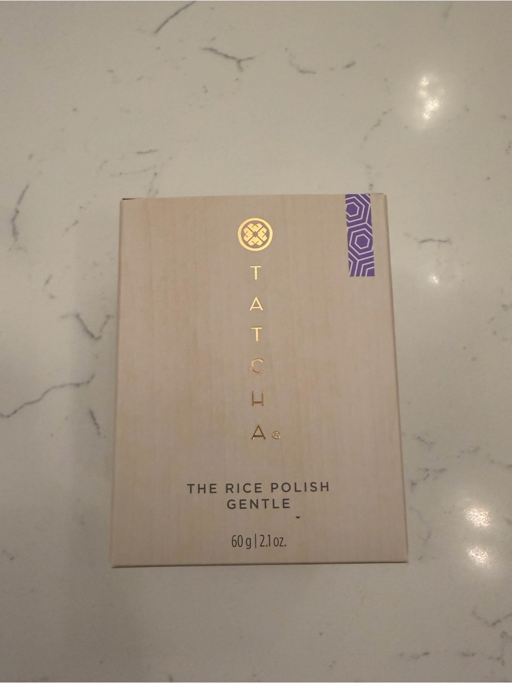 Tatcha packaging with beige board and purple accent